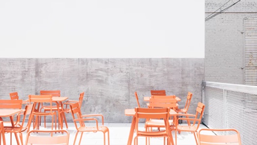 Several wooden chairs and tables are seen in an empty restaurant.