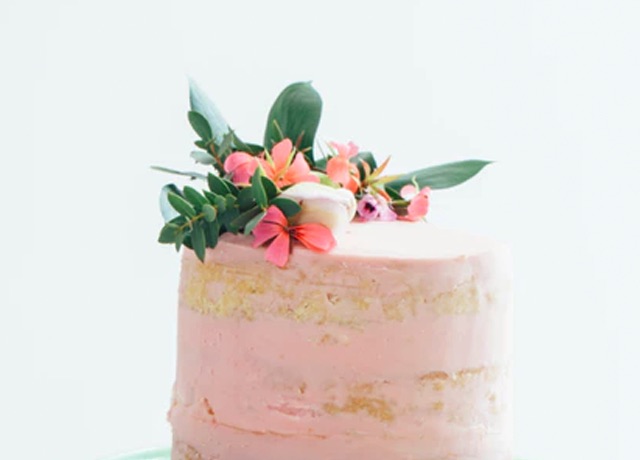 A frosted cake with a small floral arrangement on top.